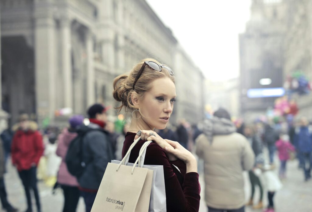 Laugh It Off: Why Humor Is the 1 Real Secret Ingredient In Weight Loss. 4 Stylish woman with shopping bags in bustling Milan street, embracing urban fashion vibes.
