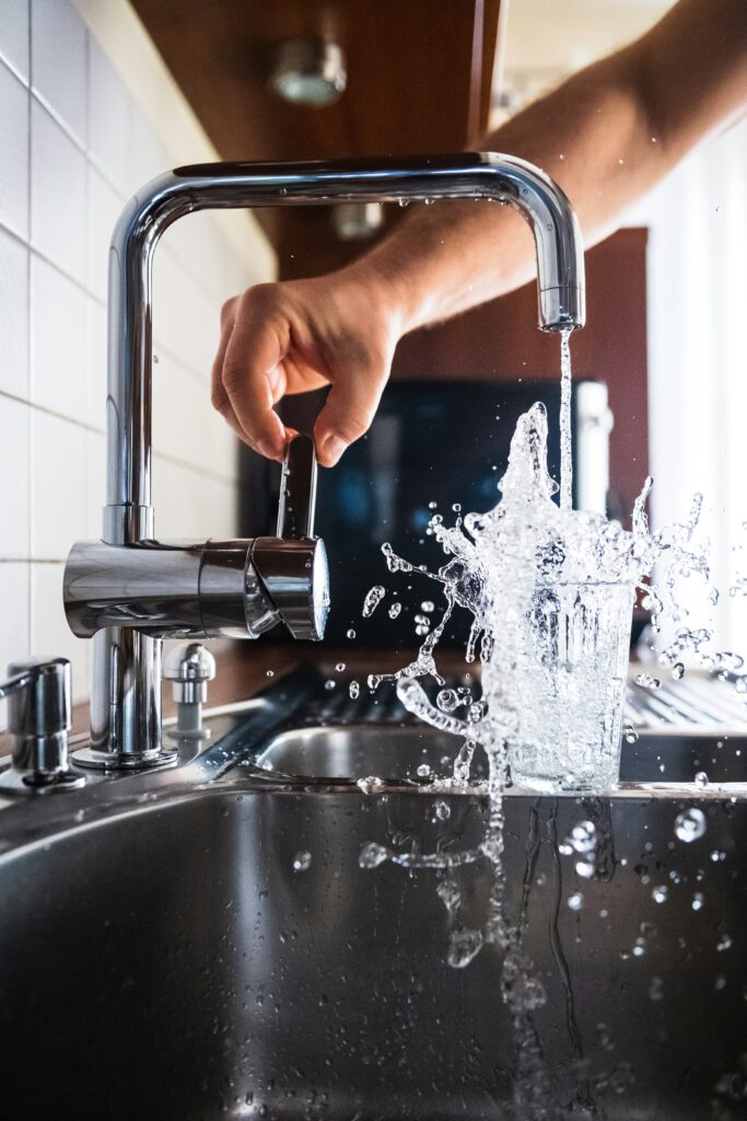 Think Before You Drink: 5 Guilt-Free Behavioral Science Hacks for Hydration 4 Hydration is shown by a hand opening up a faucet and a refreshing burst of water is pouring into a clear glass