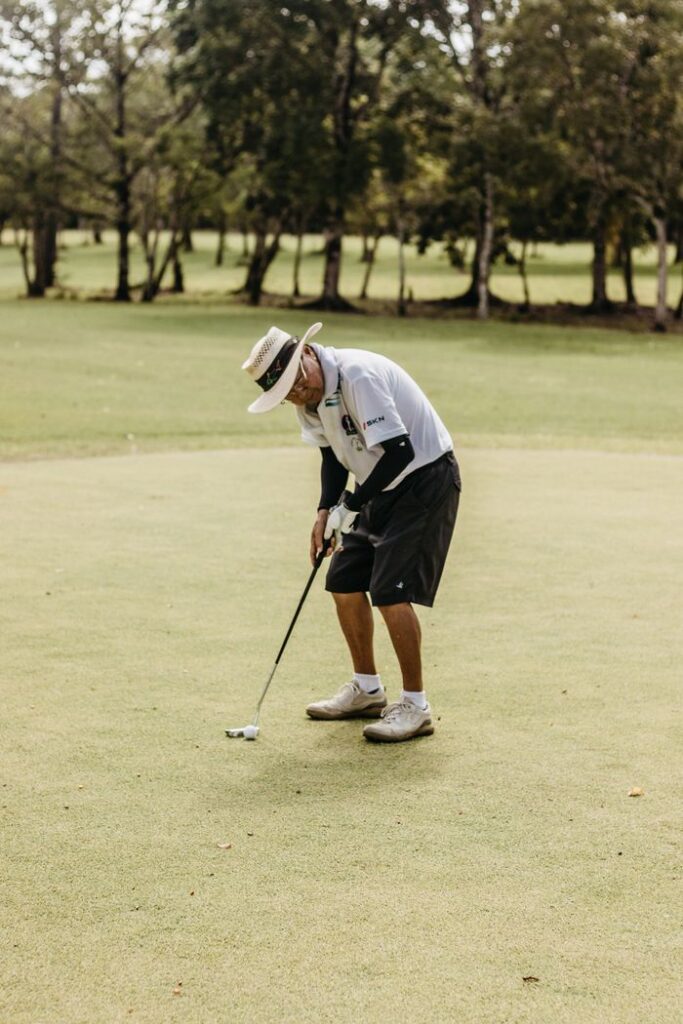 Swing Away: Golf's Secret Role in Weight Loss 3 A golfer focusing on a putt on a green course on a sunny day.